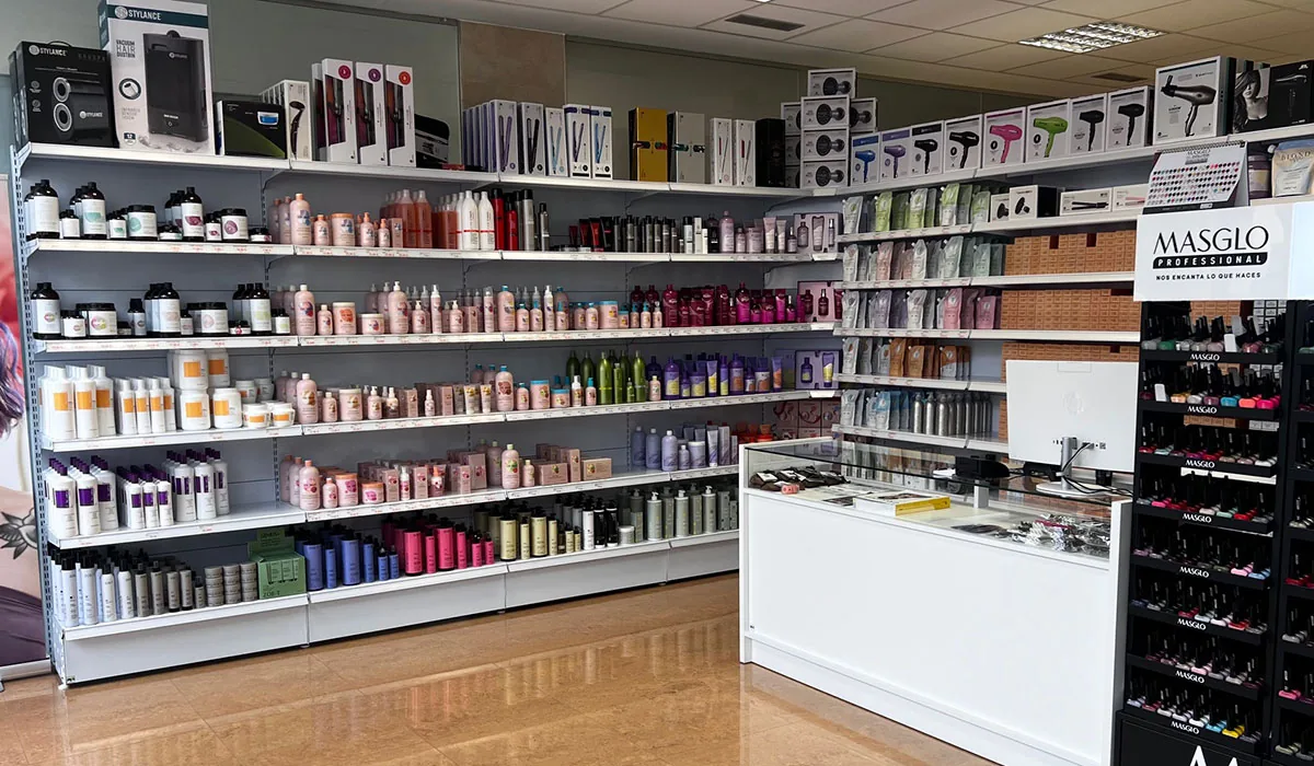 Tienda de cosméticos con murales de baldas en dos paredes y el mostrador de caja en la esquina